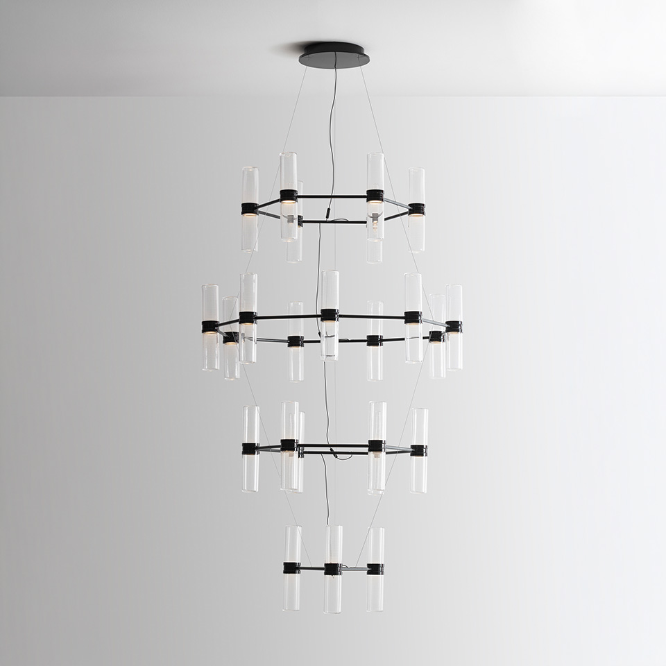 Lampadario Artemide Zephyr: tre anelli in metallo nero con diffusori cilindrici in vetro trasparente sospesi dal soffitto