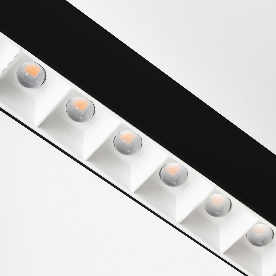 Plafoniera Artemide A.39: apparecchio lineare bianco diagonale con sei moduli LED a incasso quadrato con lenti rifrattive su binario nero