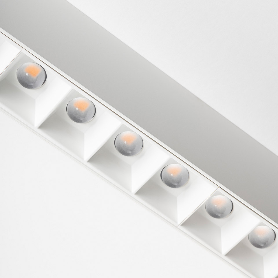 Artemide A.39 lampada da soffitto: struttura lineare bianca con sei ottiche LED a lente incassate in cornici quadrate che emettono luce direzionale calda