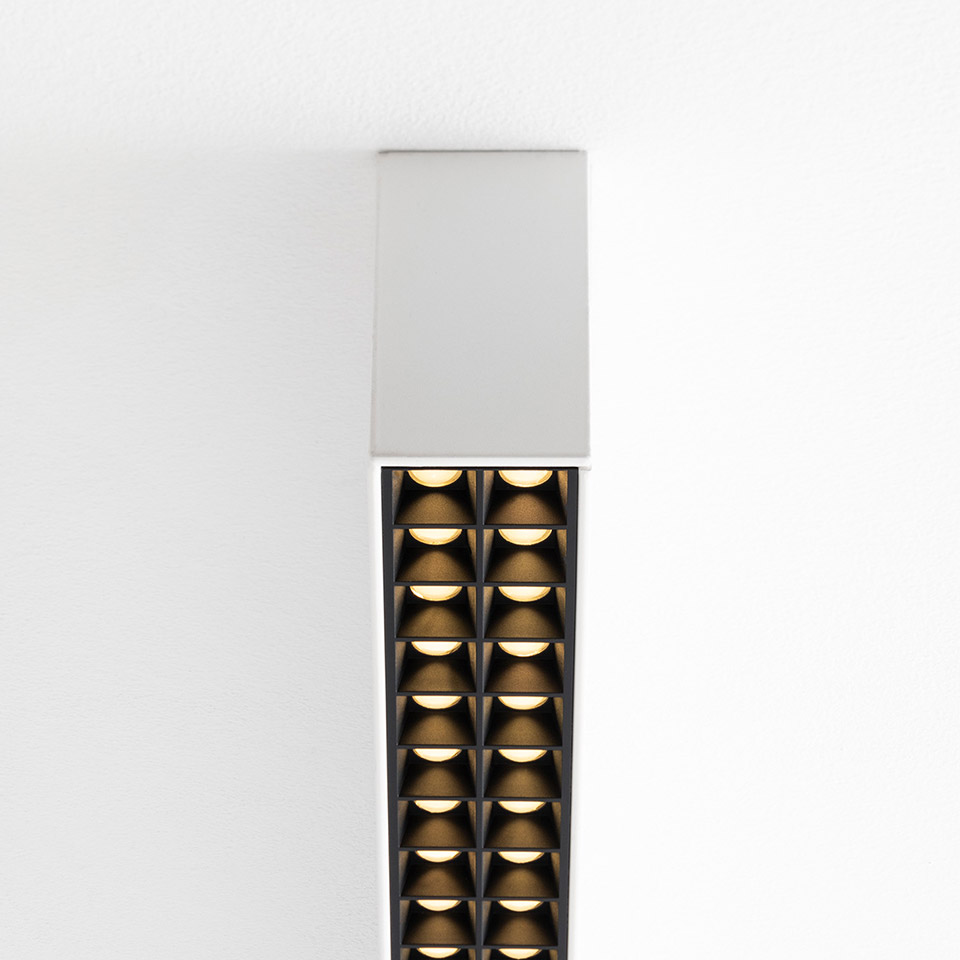 Lampada a soffitto Artemide A.39 con rosone bianco e griglia allungata scura di ottiche microrifrattive LED a doppia colonna