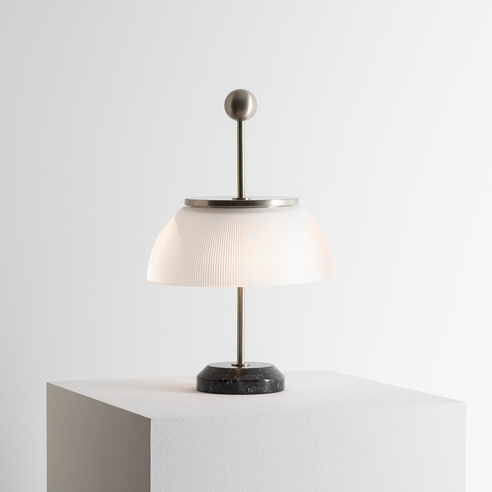 Lampada da tavolo Artemide Alfa: paralume a cupola in vetro bianco nervato, stelo in metallo spazzolato con sfera terminale, base circolare in marmo nero