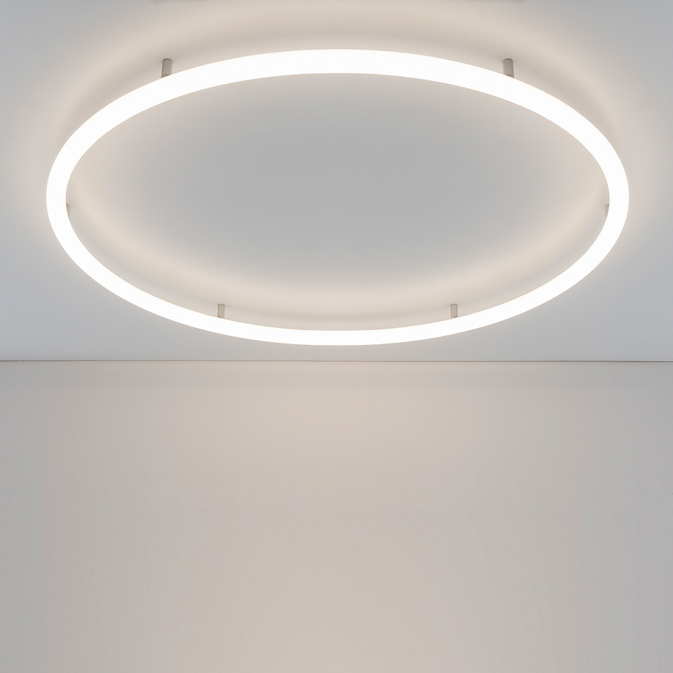Lampada da soffitto Artemide Alphabet of Light Circular: grande anello LED bianco montato a filo su soffitto bianco, con luce diffusa morbida