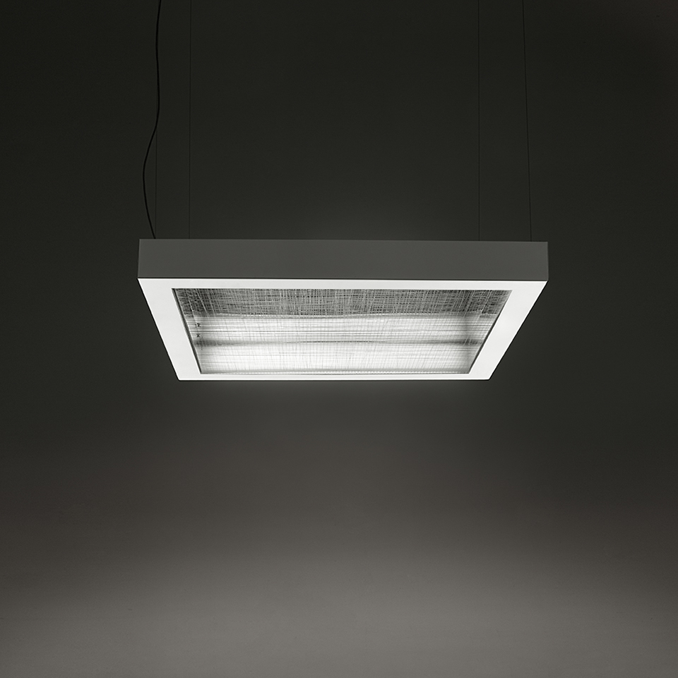 Lampada a sospensione Artemide Altrove: struttura rettangolare grigio scuro con diffusore in vetro texturizzato e tubi fluorescenti, appesa a due cavi