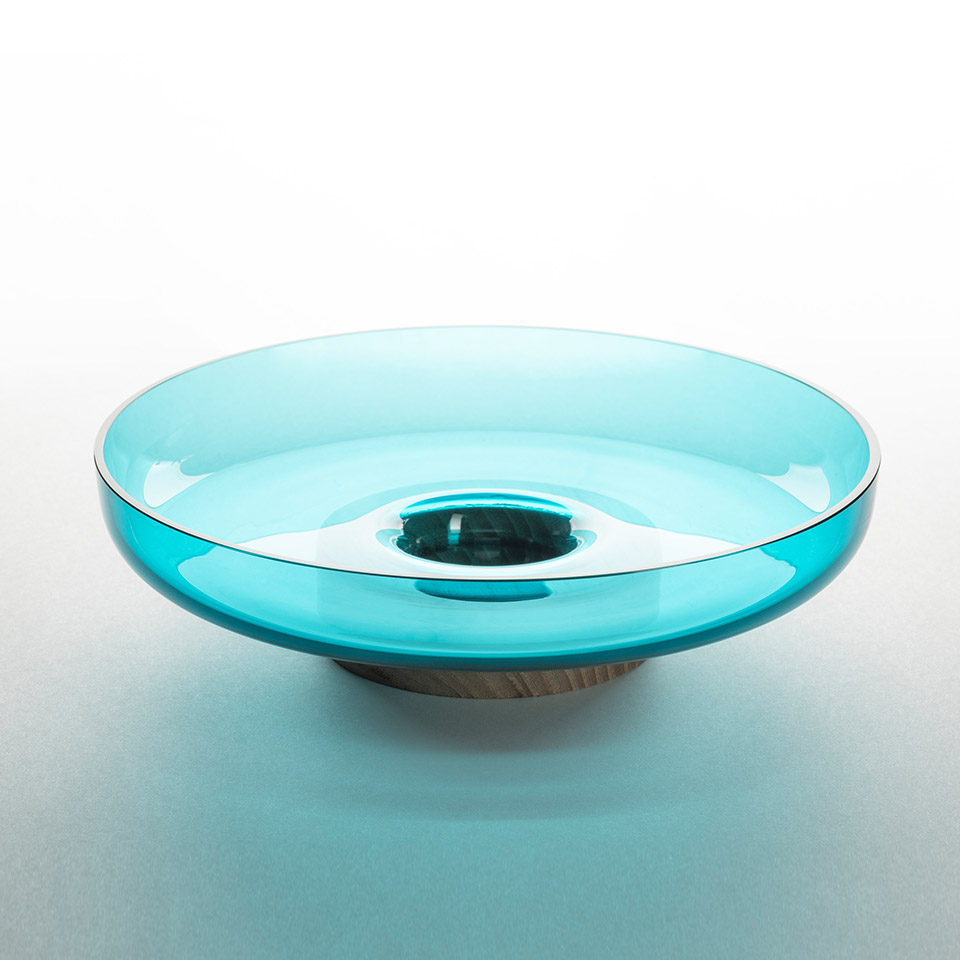 Artemide Bontà: wide shallow turquoise glass bowl with central recess, resting on a natural wood base