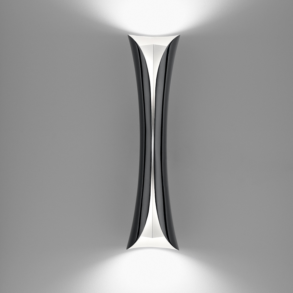 Artemide Cadmo wall lamp with hourglass-shaped black body, emitting upward and downward white light beams against a grey wall