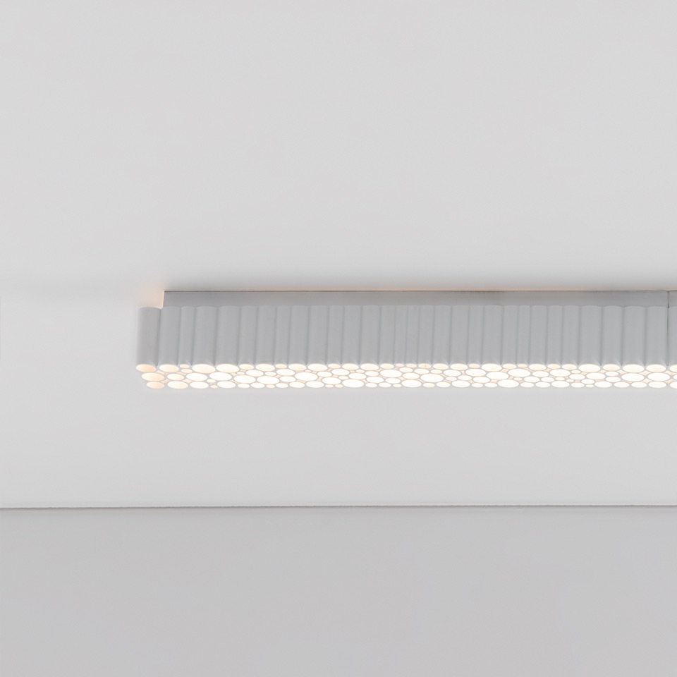 Artemide Calipso Linear System: lampada da soffitto a incasso con diffusore allungato a nido d'ape che emette luce bianca uniforme e soffusa