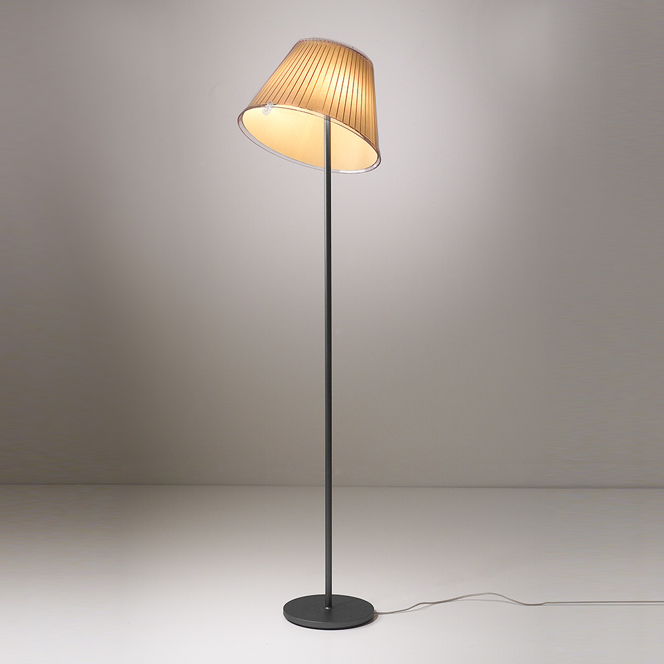 Lampada da terra Artemide Choose con paralume in tessuto plissettato inclinato su un sottile fusto in metallo scuro e base rotonda