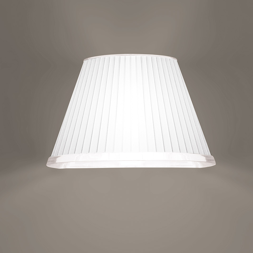 Paralume Artemide: tessuto plissettato bianco, forma conica, più larga in alto, con luce diffusa e soffusa nella parte inferiore