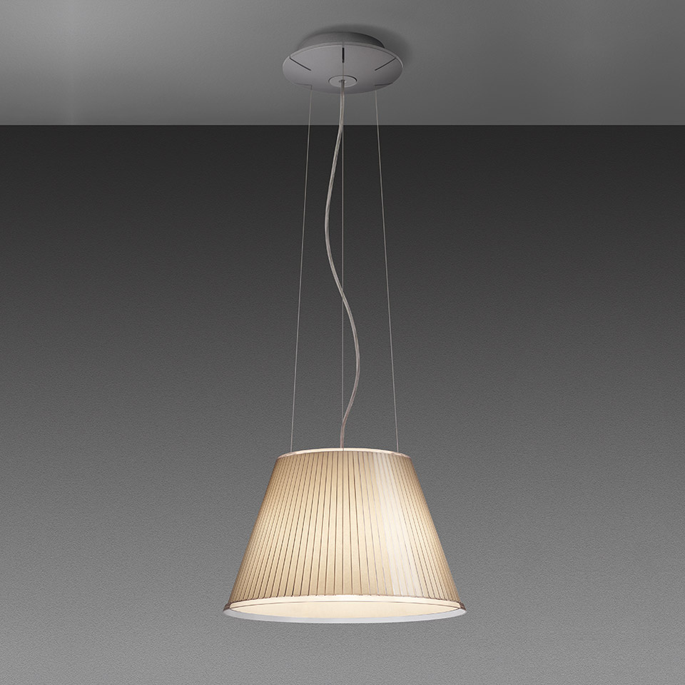Lampada a sospensione Artemide con paralume conico plissettato in tessuto beige caldo, sospesa da sottili cavi a un rosone circolare a soffitto