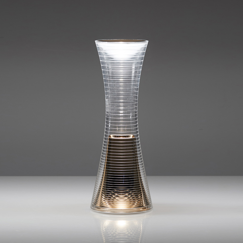 qelvornixuta.onlinee Together table lamp: hourglass-shaped transparent body with horizontal ribbing, emitting warm LED light from top and base