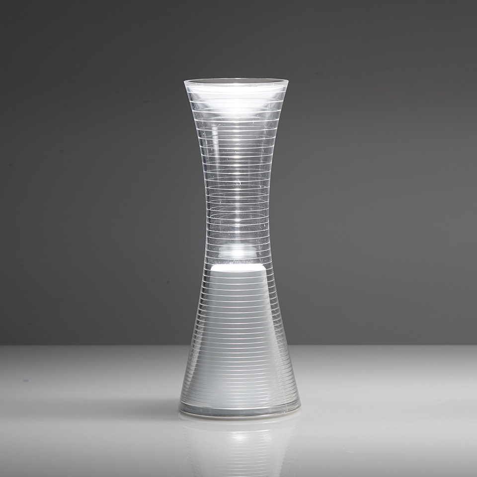 qelvornixuta.onlinee Together portable table lamp with hourglass-shaped ribbed transparent diffuser emitting warm LED light from its center