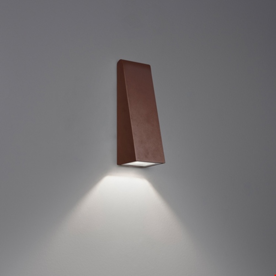 Applique Artemide Cuneo finitura corten, corpo trapezoidale angolare con fascio LED orientato verso il basso su parete neutra