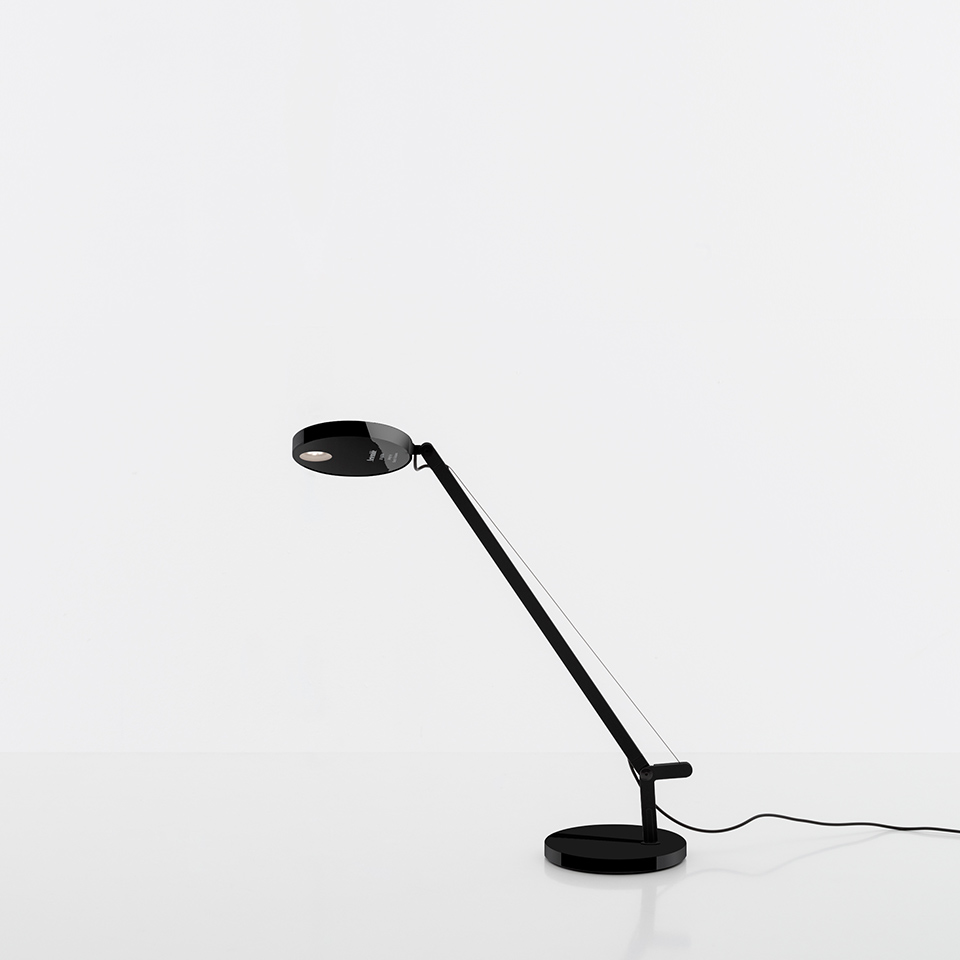 Artemide Demetra Micro table lamp in black, featuring an adjustable arm, circular disc head, and round base with tension wire.