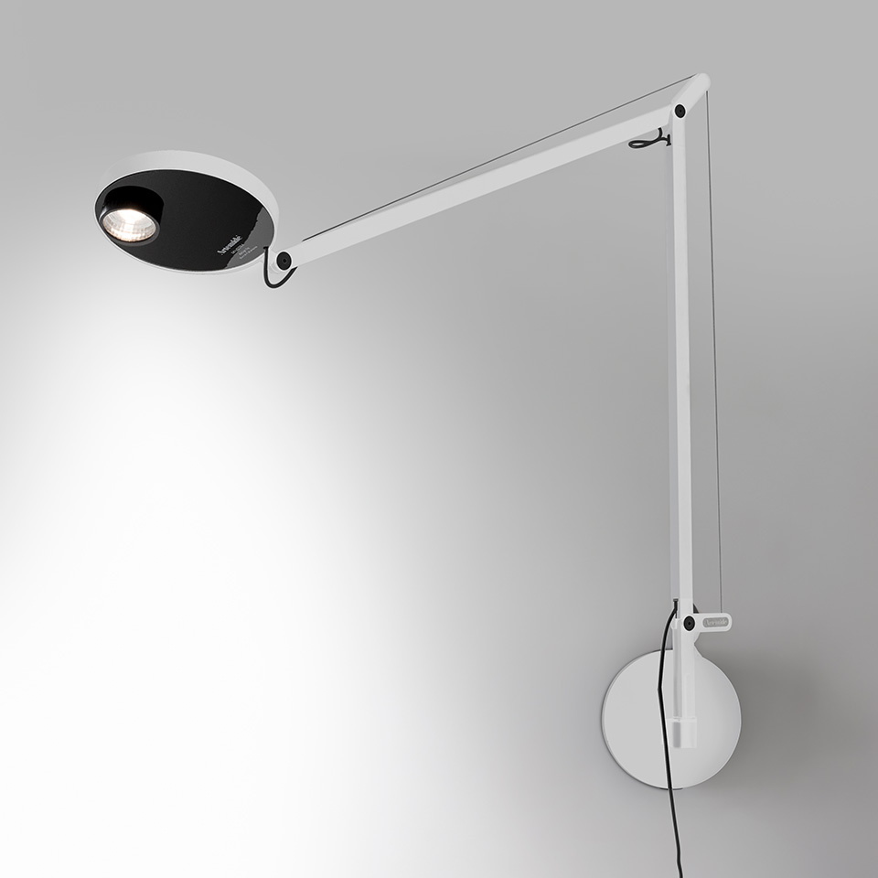Lampada da parete Artemide Demetra Professional: braccio articolato bianco con testa LED ovale nera, montata su supporto circolare a parete