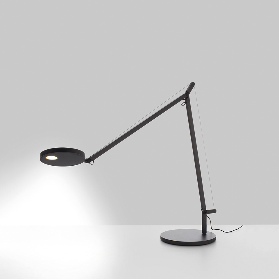 Lampada da tavolo Artemide Demetra Tavolo nera, con braccio articolato, cavo di tensione, testa LED rotonda e base circolare.