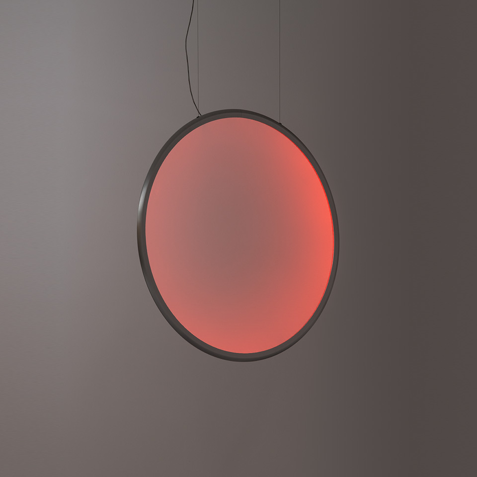 Lampada a sospensione Artemide Discovery: grande disco circolare con cornice scura che emette luce sfumata rosso-rosa calda, sospesa da cavo nero - 2