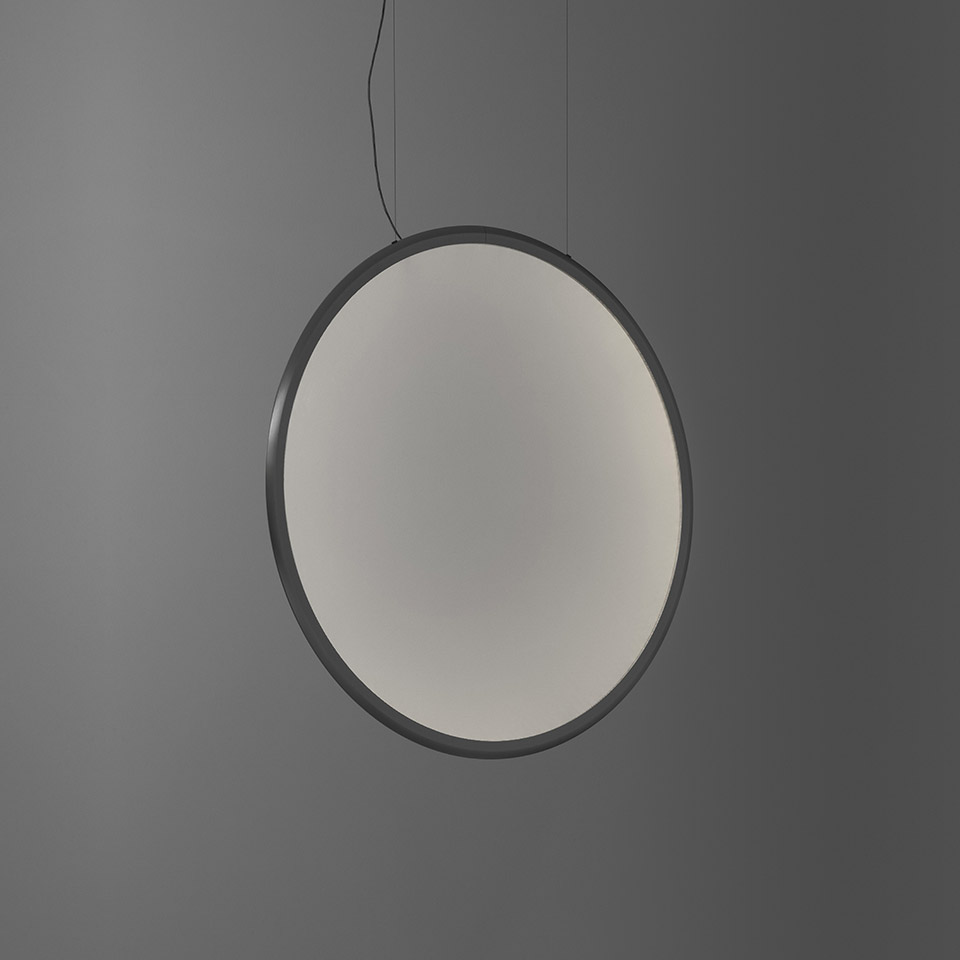 Lampada a sospensione Artemide Discovery: grande disco circolare con cornice in metallo scuro e diffusore opale, sospesa da un sottile cavo nero