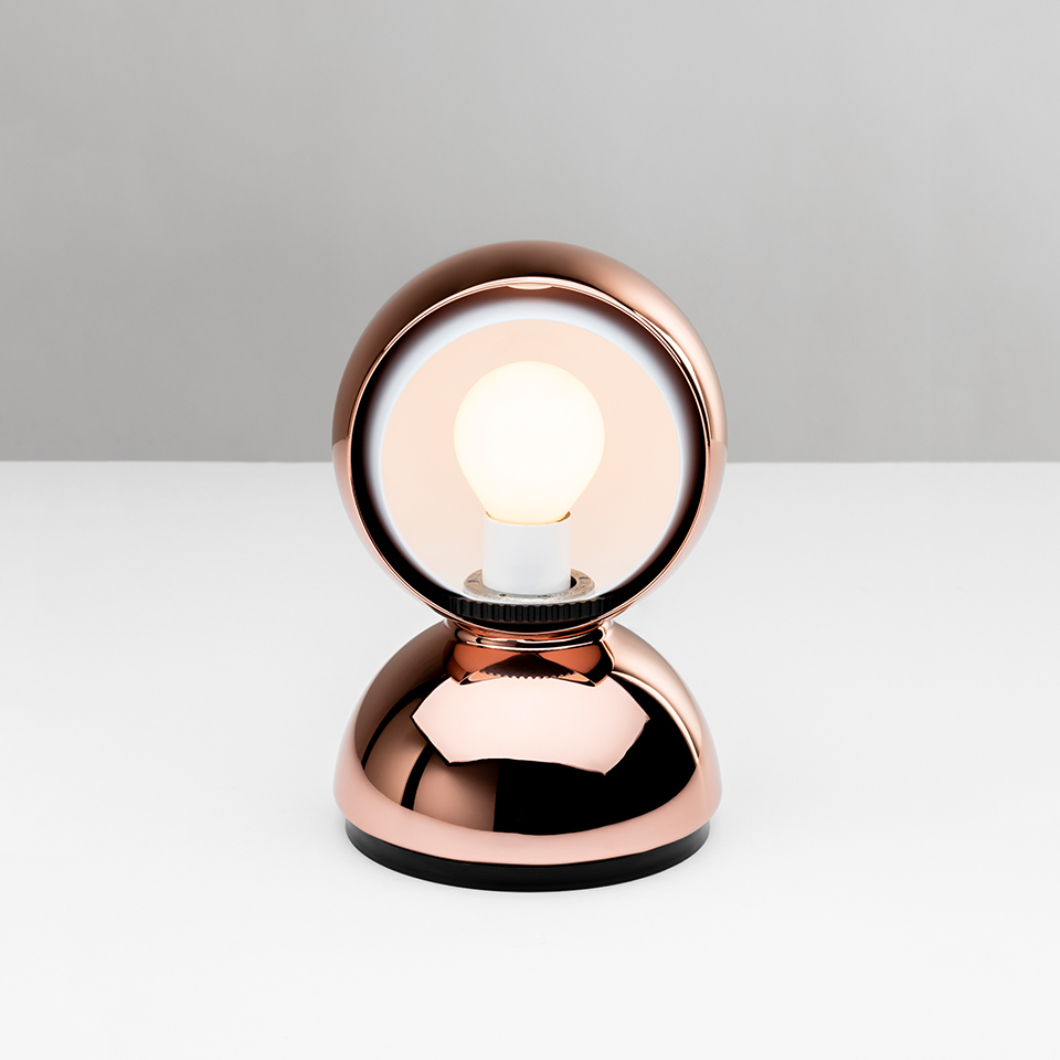 Artemide Eclisse table lamp in copper finish, featuring a round reflector disc on a dome-shaped base with exposed Edison-style bulb