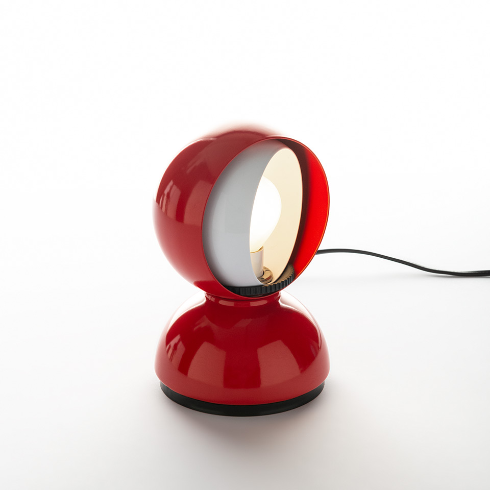 Artemide Eclisse table lamp in red, featuring a spherical rotating shade on a round base, with inner white diffuser lit.