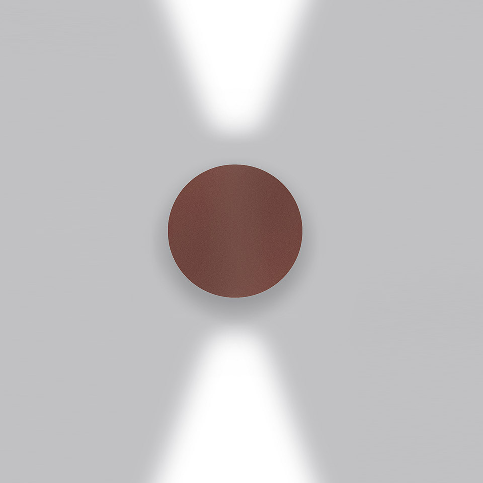 Applique da parete Artemide Effetto color bordeaux, con due fasci di luce diretti verso l'alto e il basso su parete bianca