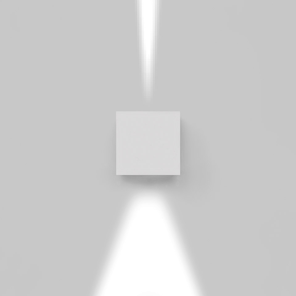 Applique Artemide Effetto bianca che emette due fasci di luce stretti verso l'alto e verso il basso su una parete neutra