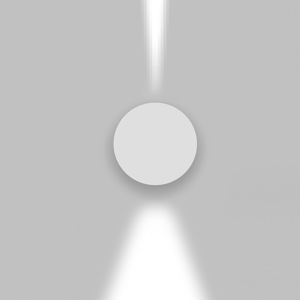 Applique da parete Artemide Effetto, corpo circolare bianco che emette fasci di luce concentrati verso l'alto e il basso su parete grigia