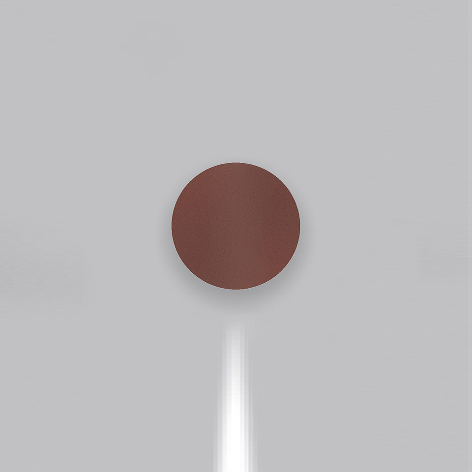 Lampada da parete Artemide Effetto color terracotta rosso, forma a disco circolare, con fascio di luce bianca diretto verso il basso