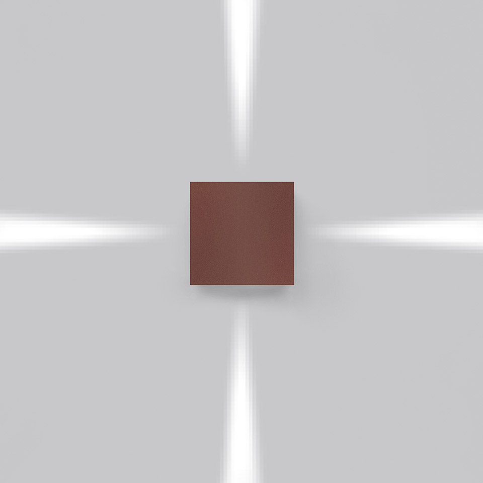 Applique Artemide Effetto color marrone, con quattro fasci di luce direzionali verso l'alto, il basso e i lati su parete grigia