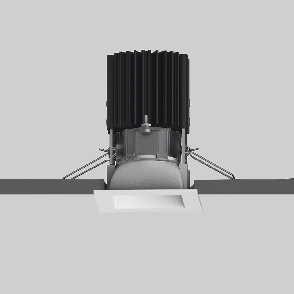 Faretto da incasso quadrato a LED Artemide Everything 55 in bianco, con dissipatore ad alette nero, mostrato durante l'installazione a soffitto