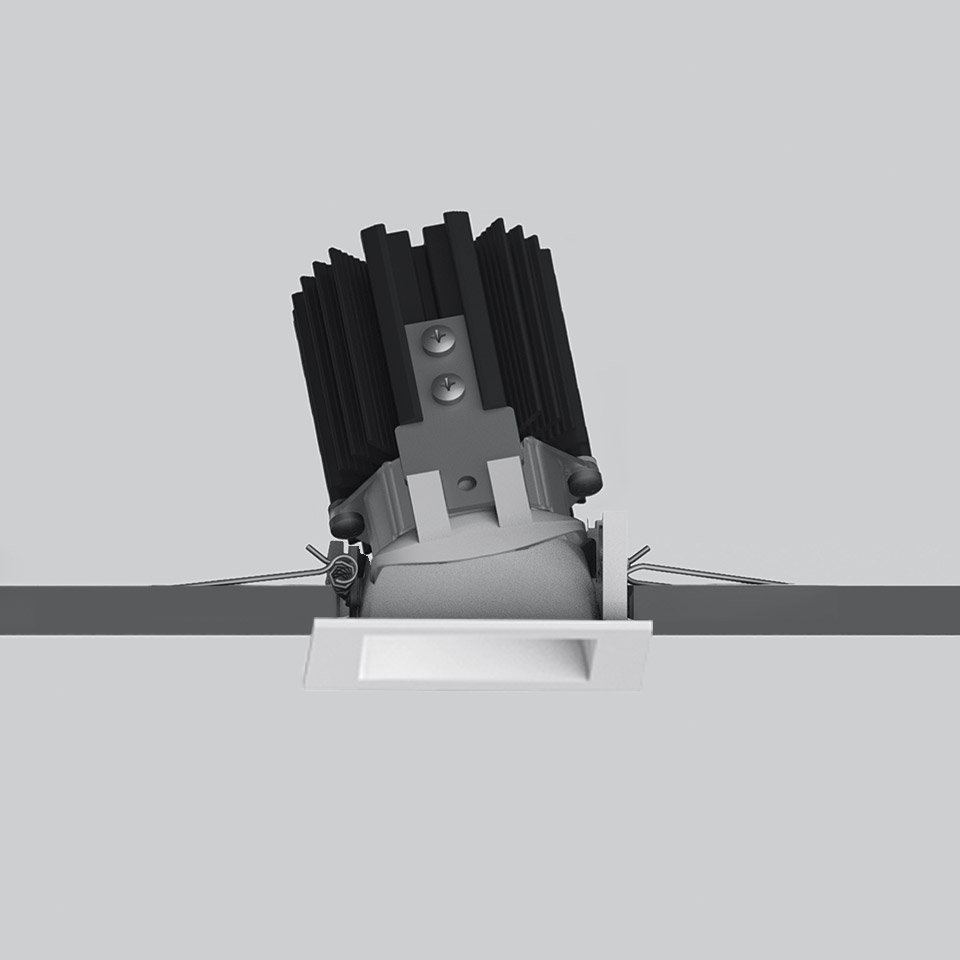 Faretto da incasso Artemide Everything 55, cornice quadrata trimless bianca, modulo LED inclinato con dissipatore nero, mostrato durante l'installazione