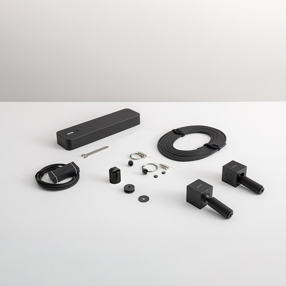 Artemide Funivia system components in black: power supply unit, flat cable coil, mounting hardware, connectors, and track end caps - 2