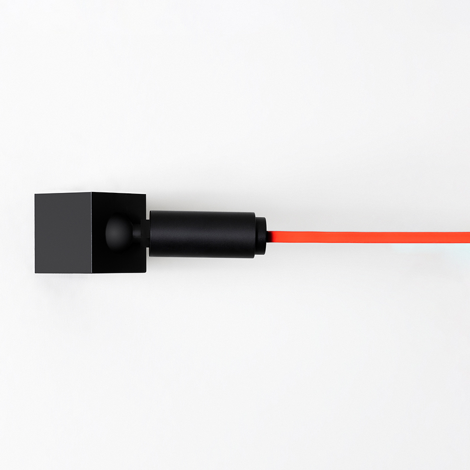 Artemide Funivia Plug wall lamp: black square bracket and cylindrical body with a bright orange cable extending horizontally
