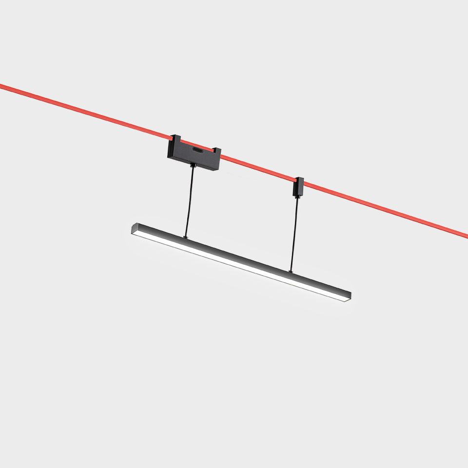 Artemide Funivia pendant light: slim dark linear LED bar suspended by cables from a red overhead cable track system