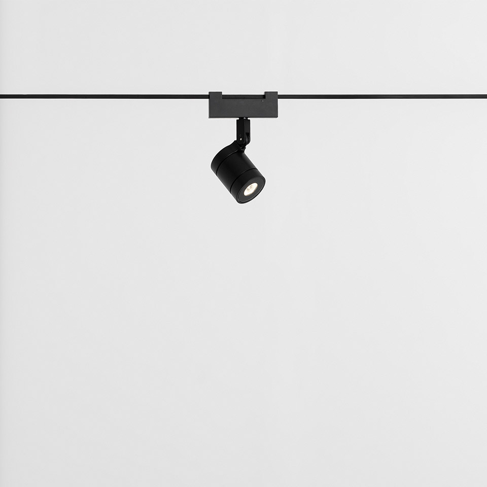 Faretto Artemide Funivia su binario: spot LED cilindrico nero montato su cavo sottile, testa orientabile per illuminazione direzionale