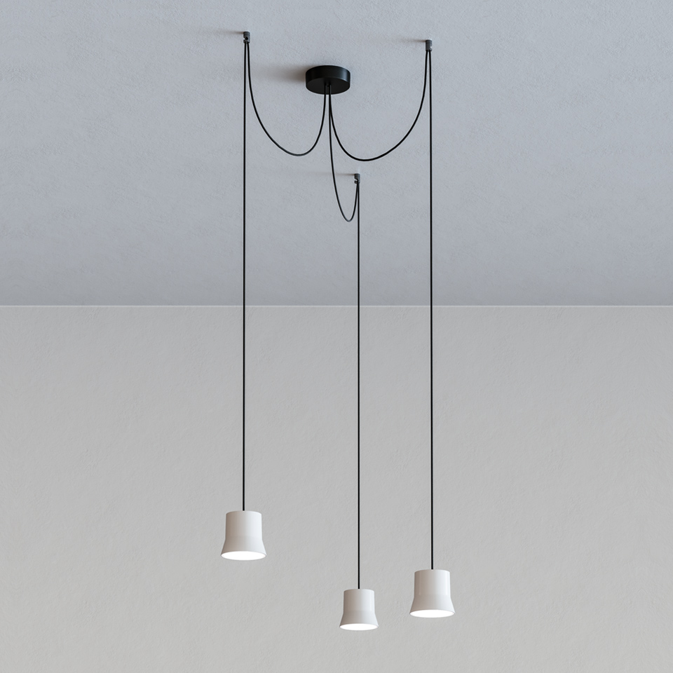 Artemide Giò Light Cluster: three white conical pendant lamps hanging at varying heights from a black ceiling canopy on thin black cords