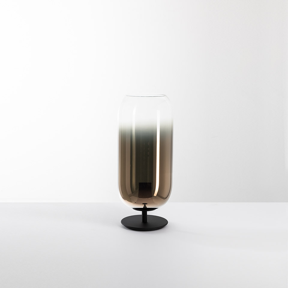 Artemide Gople table lamp: tall capsule-shaped smoked glass diffuser with bronze gradient, on a slim black metal base