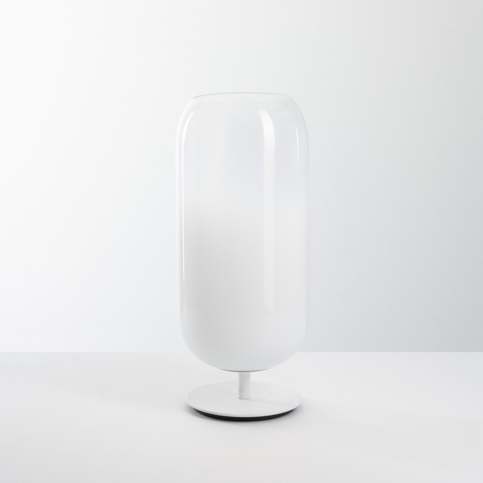 Artemide Gople table lamp: tall cylindrical white opal glass diffuser on a slim white metal base