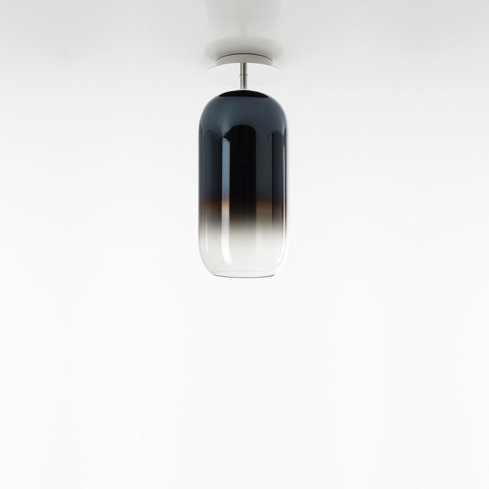Artemide Gople ceiling lamp with elongated capsule-shaped glass shade, gradient from deep blue-black at top to clear at bottom, chrome fitting