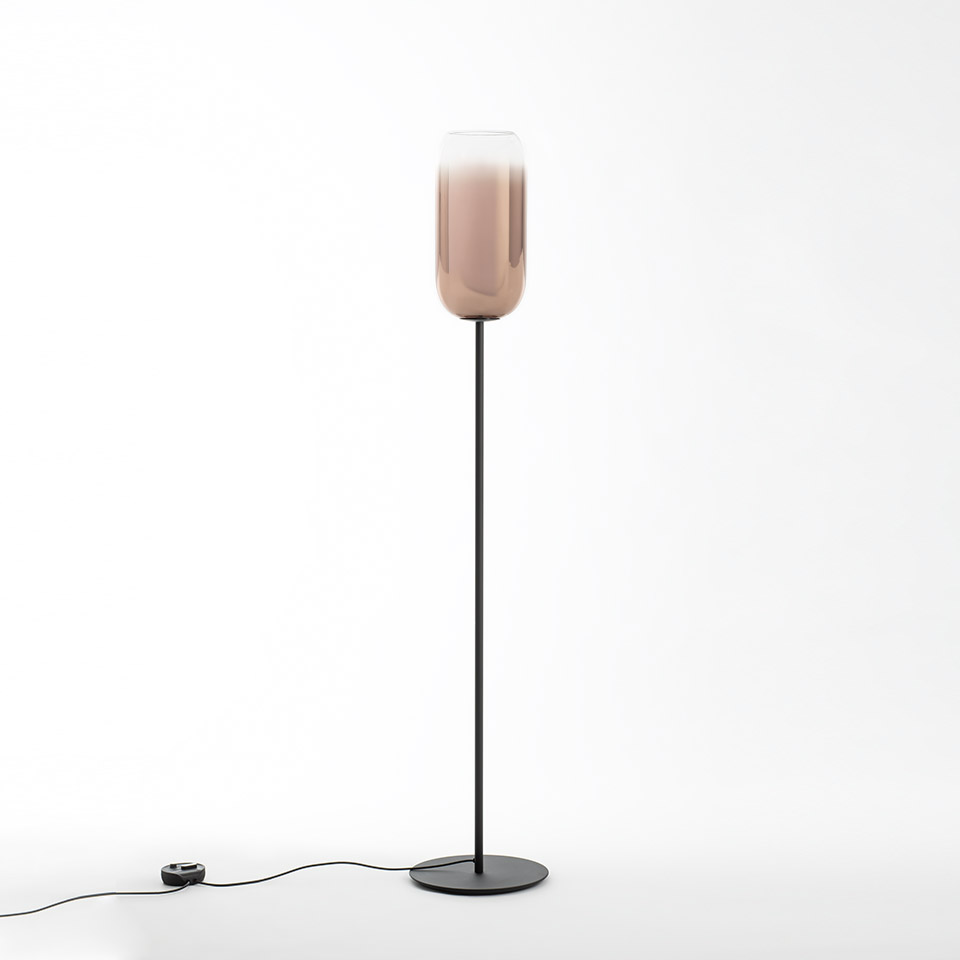 Artemide Gople floor lamp: tall black metal stem with round base, elongated rose-tinted glass shade graduating from clear to blush pink