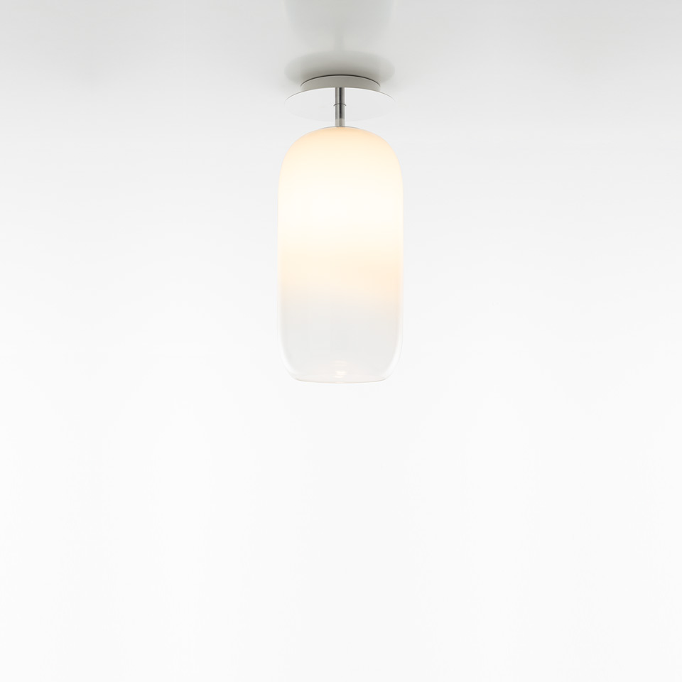 Artemide Gople ceiling lamp with opal white blown glass shade in elongated capsule shape, mounted on chrome fixture