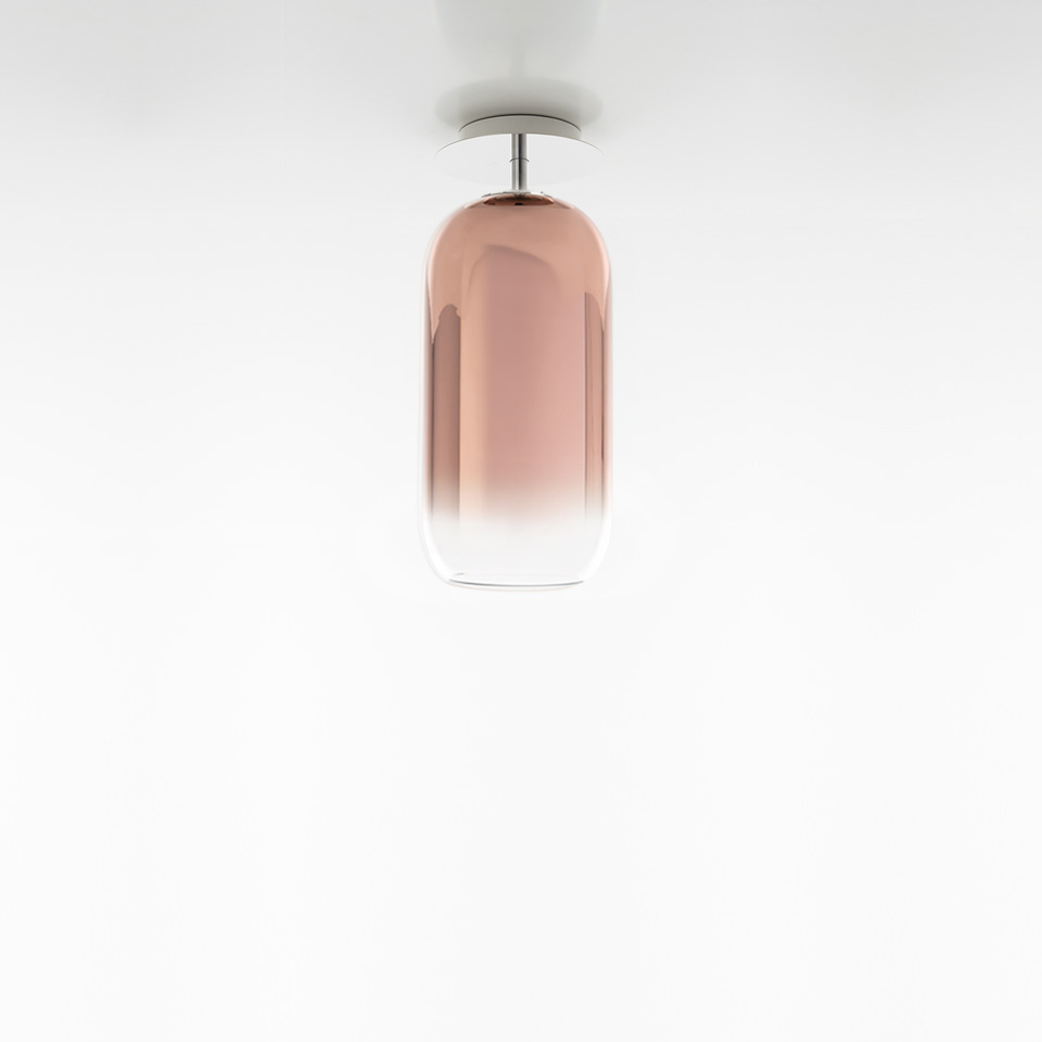 Artemide Gople ceiling lamp with elongated capsule-shaped rose-tinted glass diffuser, transitioning from pink to clear, chrome fitting
