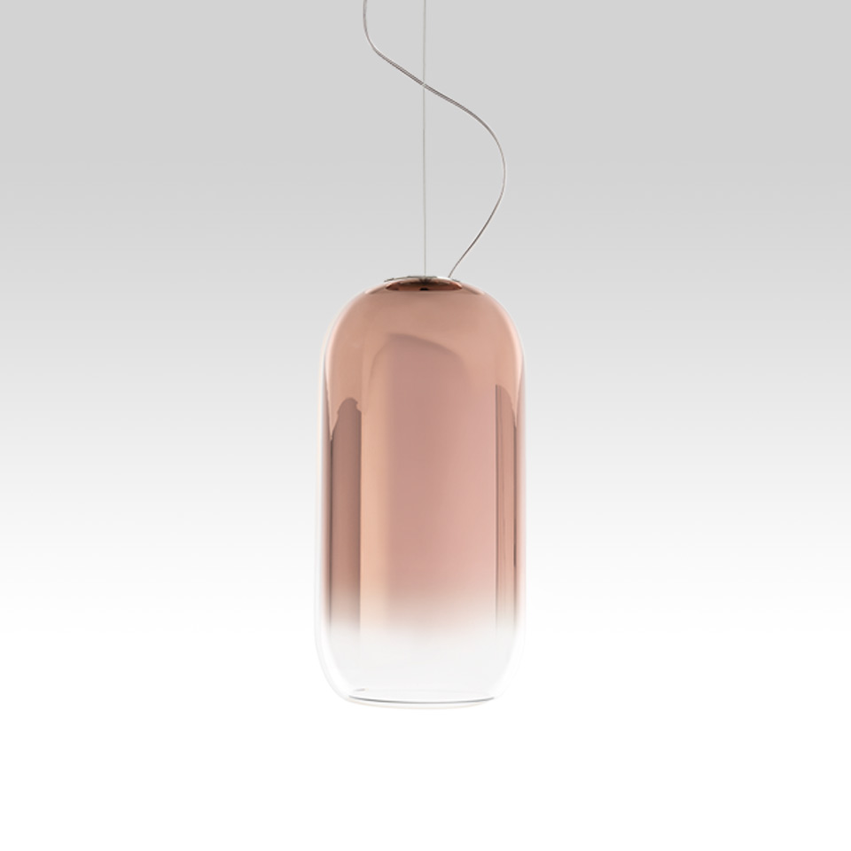 Artemide Gople pendant lamp: tall capsule-shaped blown glass shade with gradient from copper-rose to clear, suspended by steel cable