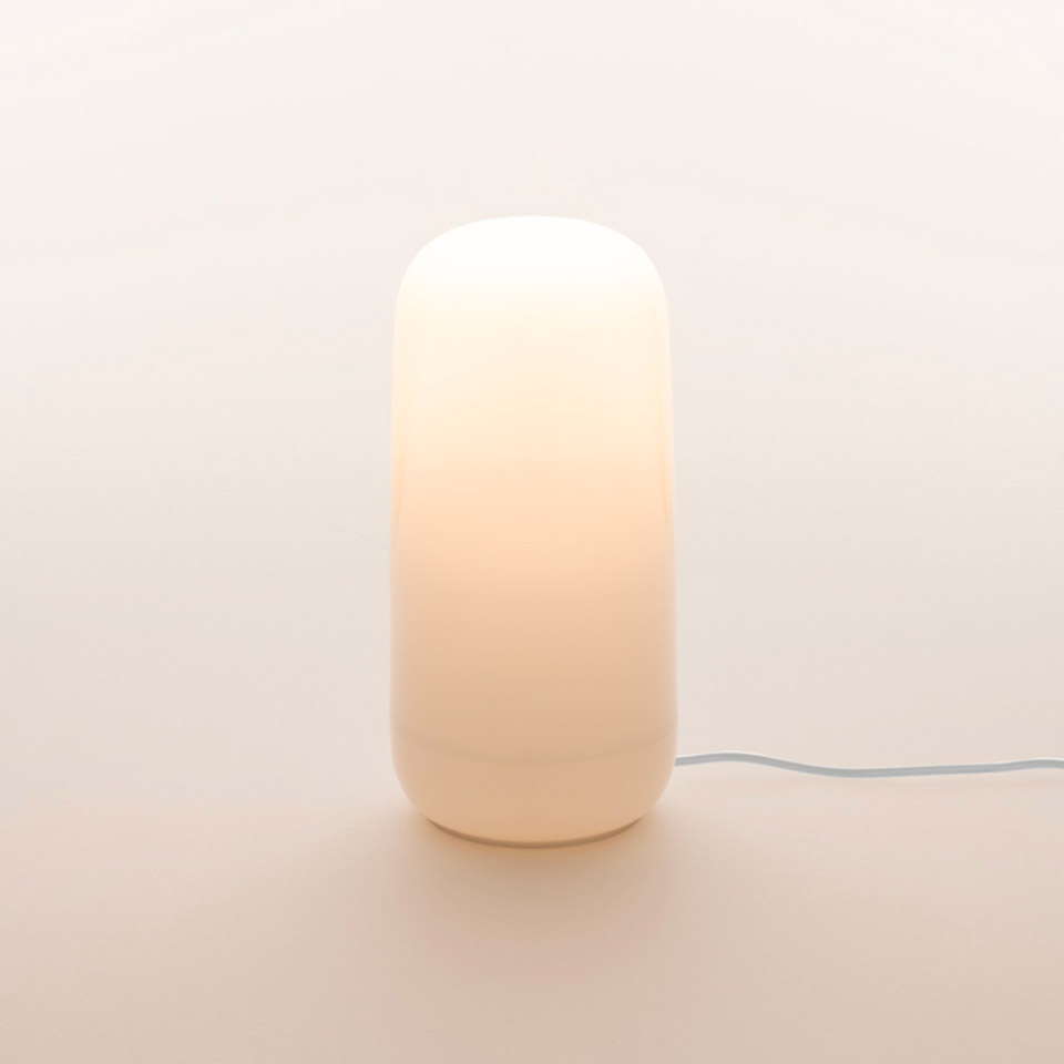 Lampada da tavolo Artemide Gople Portable: diffusore in vetro opalino bianco a forma di capsula luminosa con luce calda d'ambiente e cavo bianco