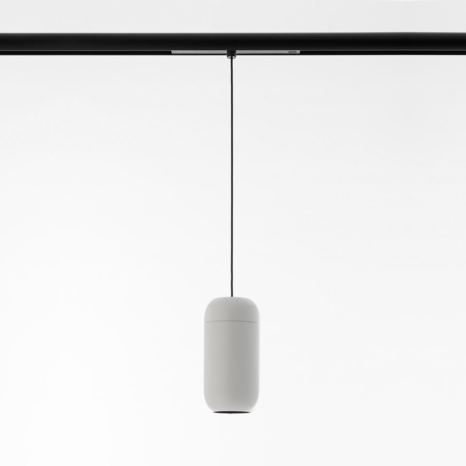 Lampada a sospensione Artemide Gople System: diffusore bianco a capsula sospeso da cavo nero su binario nero