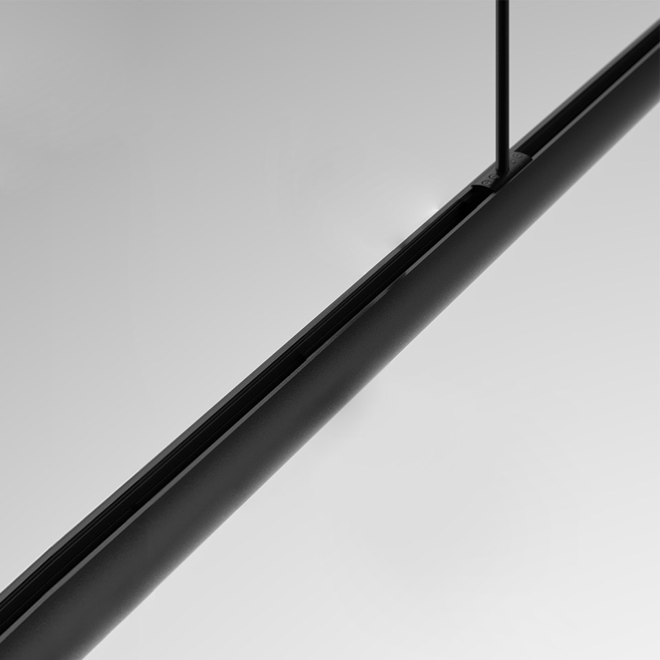 Primo piano del sistema lineare a sospensione Artemide Gople System: elegante tubo cilindrico nero sorretto da un sottile stelo nero su sfondo grigio