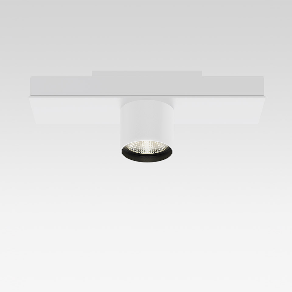 Artemide Hoy System: faretto LED cilindrico bianco con bordo nero montato su binario magnetico piatto bianco