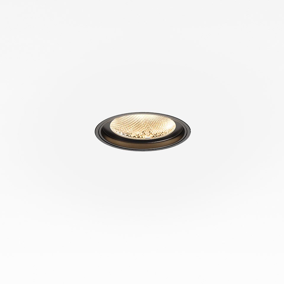 Faretto da incasso a soffitto Artemide Hoy Spot con bordo circolare nero e luce LED calda attraverso lente texturizzata