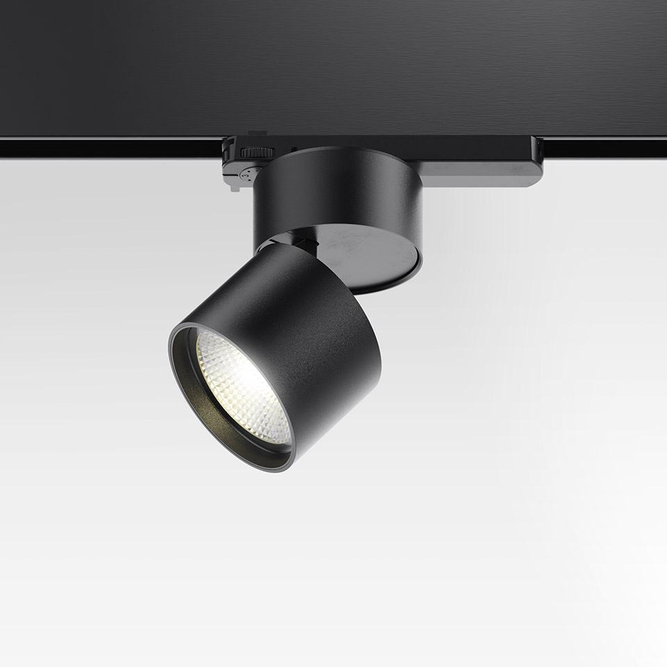 Artemide Hoy Spot 3-Phase Track: faretto LED cilindrico nero montato su binario nero, inclinato ad angolo