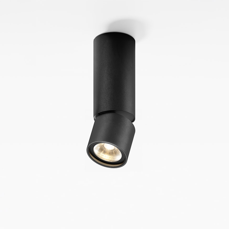 Artemide Hoy Spot SMD: faretto da soffitto cilindrico nero con testa orientabile, che emette luce bianca calda verso il basso