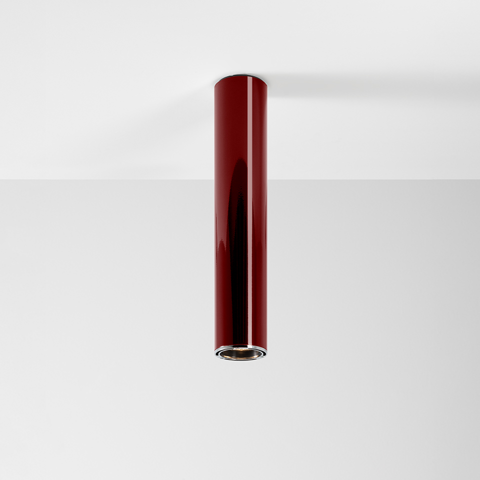 Artemide Ilio ceiling spotlight: slim glossy red cylindrical body with chrome LED aperture, surface-mounted downlight